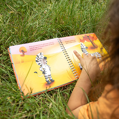 Enfant souriant qui regarde un livre avec sa photo