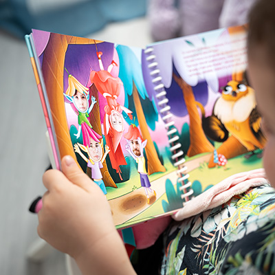 Enfant souriant qui regarde un livre avec sa photo